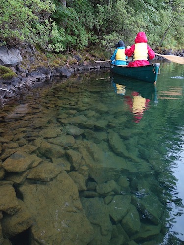 透明度の高い然別湖に浮かぶカヌーを写したツアー写真