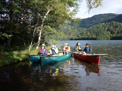 数艇のカヌーが湖上に浮かんで休憩している様子を写したツアー写真