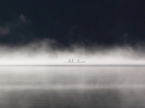 毛嵐が立ち込めた湖面を進むカヌーを写したツアー写真