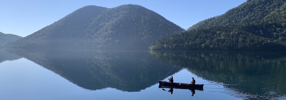 早朝の然別湖に浮かぶカヌーとくちびる山